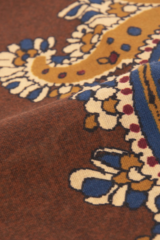 the detail of yellow and blue design on a brown wool scarf