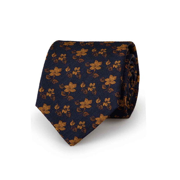 Italian luxury sartorial jacquard tie with gold flower on a dark blue background