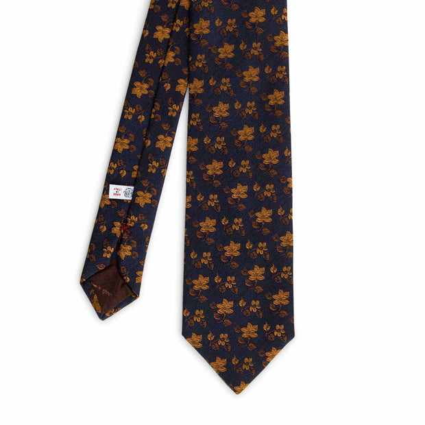 Front view of a italian tie with golf flower on a dark blue background

