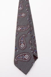 Cravatta sfoderata in seta jacquard con fondo grigio melange con grandi paisley rossi bianchi e azzurri   - Fumagalli 1891