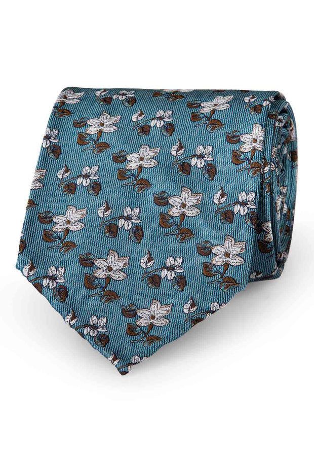 floral patterned tie with white flowers and green leaves on a turquoise background